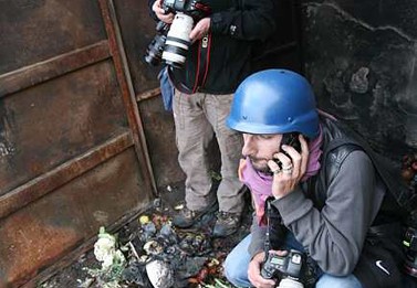 מהומות בשועפאט. צלמים מתחבאים במכולת אשפה. דצמבר 2008 (צילום: יוסי זמיר)
