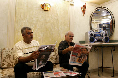 קוראים עיתון במספרה באום אל-פחם, נובמבר 2006 (צילום: דניאל בר-און)