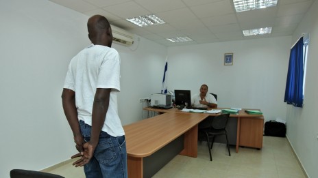 פליט סודאני ושוטר במחנה המעצר בקציעות, 3.8.09 (צילום: משה שי)