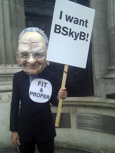 מפגין נגד עסקת הרכישה של בריטיש-סקיי על-ידי מרדוק, מול לשכת שר התקשורת. לונדון, יולי 2011 (צילום: 38degrees, רישיון cc)