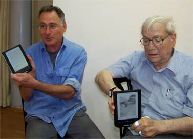 הסופרים יורם קניוק (מימין) ואיל מגד, אוחזים במכשירי עברית (צילום: עידו קינן, חדר 404, cc-by-sa)