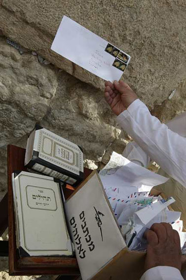 פתקים שנשלחו בדואר נתחבים בין חרכי הכותל המערבי בירושלים(צילום: קובי גדעון)