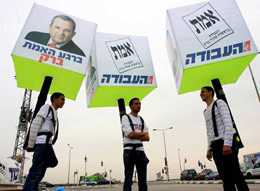 נושאים על גבם שלטי בחירות, אתמול ליד אשקלון (צילום: אדי ישראל)