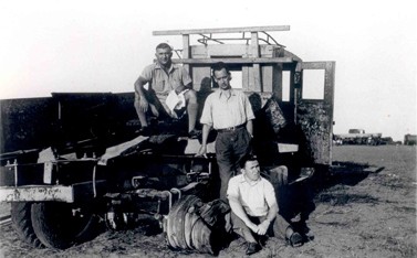 גבריאל צפרוני (יושב על הקרקע) ליד משאית שמוקשה בדרך שבין כפר-סבא לקיבוץ רמת-הכובש, 1938. עומד: אריה דיסנצ'יק (צילום: שריה שפירא, באדיבות בתו, תאירה. לחצו להגדלה)