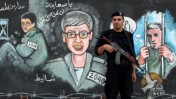 שוטר חמאס על רקע ציורי קיר של גלעד שליט (צילום: ויסאם נסאר)