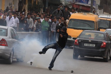 פלסטיני בועט ברימון גז, אתמול, ליד רמאללה (צילום: עיסאם רימאווי)