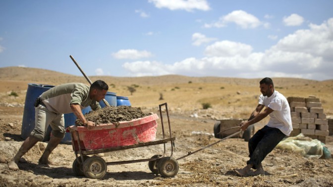 פלסטינים עובדים במפעל לבנים ביתי בג'יפטליק, בקעת הירדן, אתמול (צילום: מתניה טאוסיג. לחצו להגדלה)