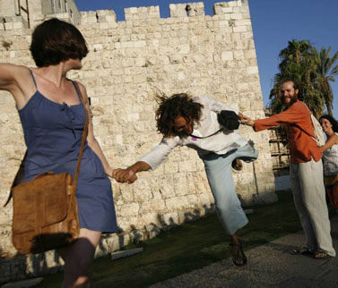 "החיבוק הגדול", אירוע שהתרחש אתמול ובמסגרתו החזיקו כמה עשרות פעילים ידיים מול חומות העיר העתיקה בירושלים ושרו שירי שלום (צילום: מרים אלסטר)