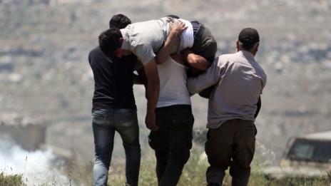 פלסטינים נושאים פצוע בעקבות עימות עם מתנחלים ליד יצהר, אתמול (צילום: עיסאם רימאווי)