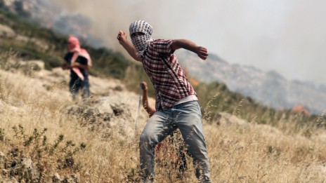 פלסטיני משליך אבן, שלשום ליד רמאללה (צילום: עיסאם רימאווי)