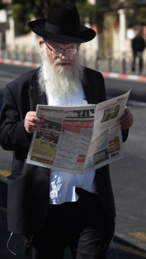 גבר מעיין בגיליון של "יתד נאמן" בשכונת מאה-שערים בירושלים, 7.11.2011 (צילום: קובי גדעון)