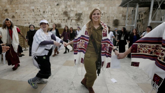 אשה לבושה מדי צבא וטלית רוקדת יחד עם חברות ארגון "נשות הכותל" סמוך לכותל המערבי בעיר העתיקה בירושלים, 3.3.14 (צילום: מרים אלסטר)