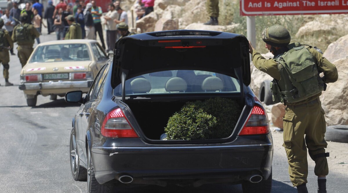 חייל ישראלי בודק תא מטען של פלסטינים, במסגרת המבצע לאיתור הנעדרים. חברון, 15.6.14 (צילום: הדס פרוש)