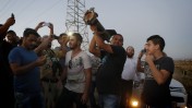 ישראלים מצטלמים עם שרידי רקטה שנורתה מרצועת עזה ונפלה ליד שדרות, ביום השישי למבצע "צוק איתן", 13.7.14 (צילום: מרים אלסטר)
