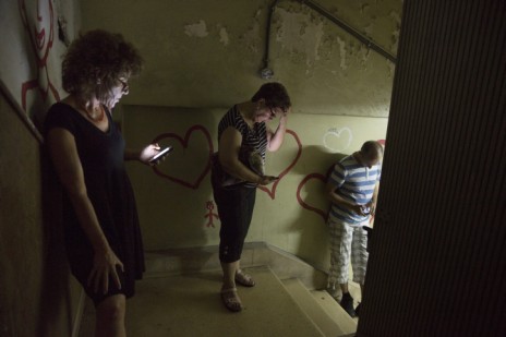 ישראלים מתחבאים בחדר מדרגות בתל-אביב בעת הישמע האזעקה. היום התשיעי של מבצע "צוק איתן", 16.7.14 (צילום: מתניה טאוסיג)