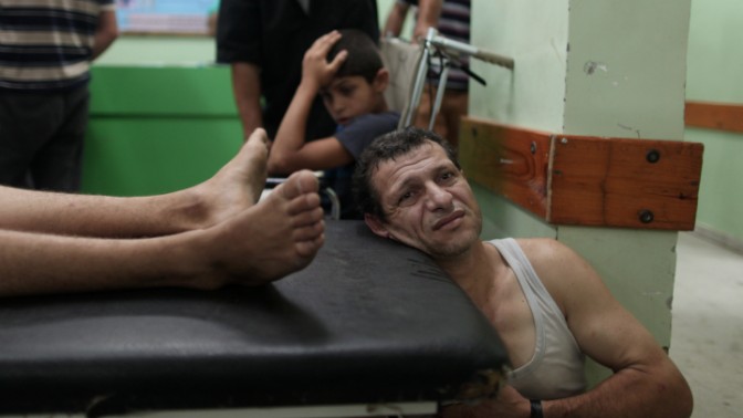 פצוע פלסטיני מהפצצת צה"ל בג'בליה ממתין בבית-החולים בבית-להייא, 30.7.14 (צילום: עמאד נאסר)