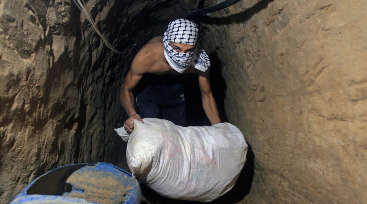 פלסטיני רעול פנים מעביר שק במנהרה, היום לפני שש שנים. רצועת עזה, 29.7.08 (צילום: פאדי עדואן)
