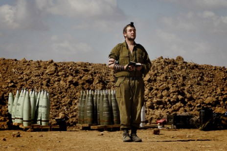 חייל צה"ל עטור תפילין מתפלל ליד הגבול עם רצועת עזה במהלך מבצע "צוק איתן", 16.7.14 (צילום: מרים אלסטר)
