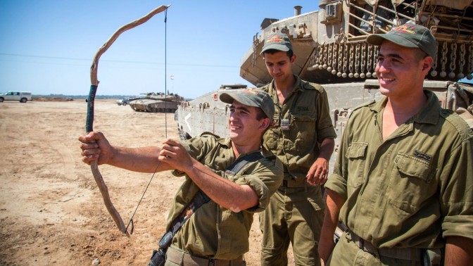 חייל ישראלי מתנסה בשימוש בקשת. פאתי עזה, 20.8.14 (צילום: אלברט סדיקוב)