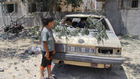 ילדים פלסטינים משחקים במכונית הרוסה, 22.8.14 (צילום: מוסטפה אשקר)