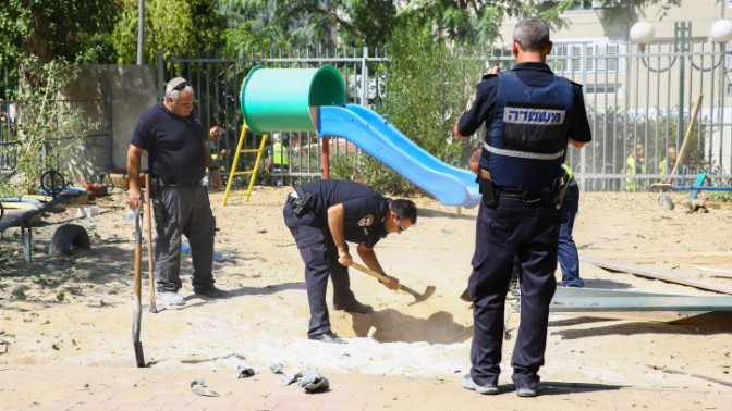 אנשי ביטחון בגן ילדים שנפגע מרקטה פלשתינית שנורתה מרצועת עזה, אשדוד, 26.8.14 (צילום: פלאש 90)