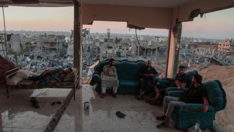 פלסטינים יושבים בביתם שבשכונת סג'עיה ברצועת עזה, 28.8.14 (צילום: עימאד נאסר)