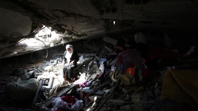 פלסטינית יושבת בחורבות ביתה שנהרס בהפצצת צה"ל במהלך מבצע "צוק איתן", ממזרח לחאן-יונס, 13.9.14 (צילום: עבד רחים חטיב)