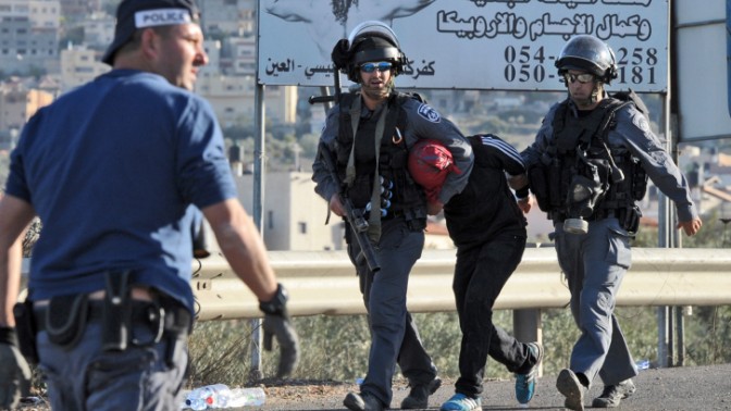 שוטרים עוצרים צעיר ערבי במהלך מהומות בכפר כנא, 9.11.14 (צילום: פלאש 90)