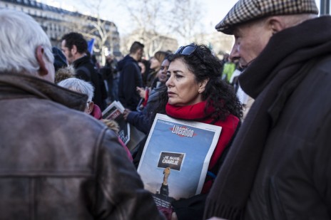 אשה אוחזת בשער גליון ה"ליברסיון" המוקדש לטבח ב"שרלי הבדו", בעצרת ההמונים בפריז, 11.1.15 (צילום: ניל בדח)