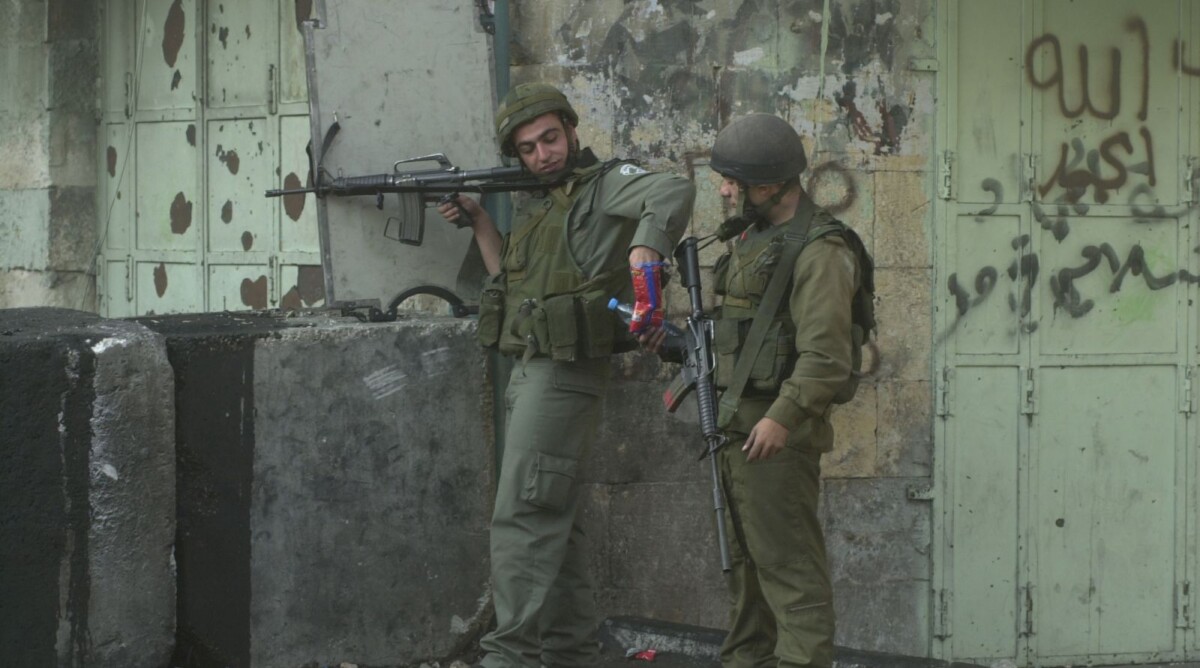 לוחמים ישראלים חולקים חטיף מלוח. חברון, 2000 (צילום: נתי שוחט)