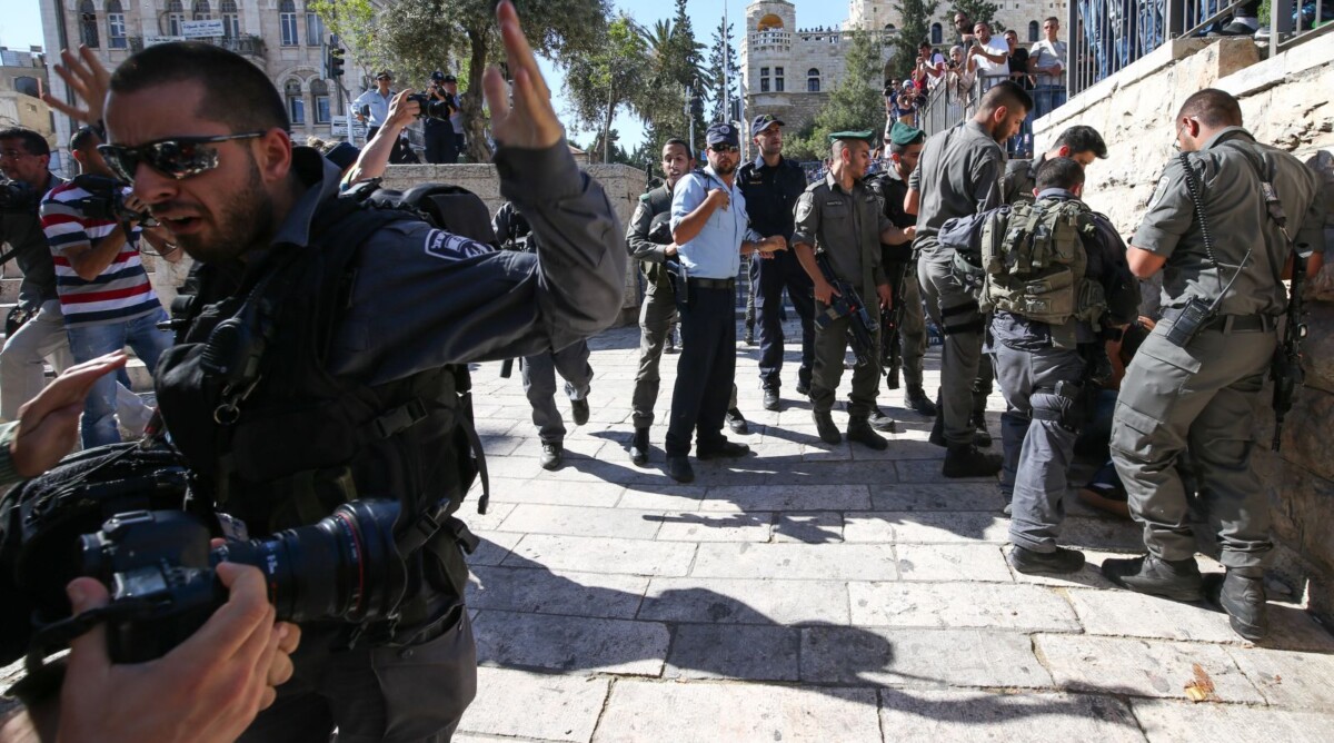 קבוצה של שוטרים מכה פלסטיני בעת ששוטר אחר מפריע לצלמים לתעד את התקרית. שער שכם, יום ירושלים, 17.5.15 (צילום: "העין השביעית")