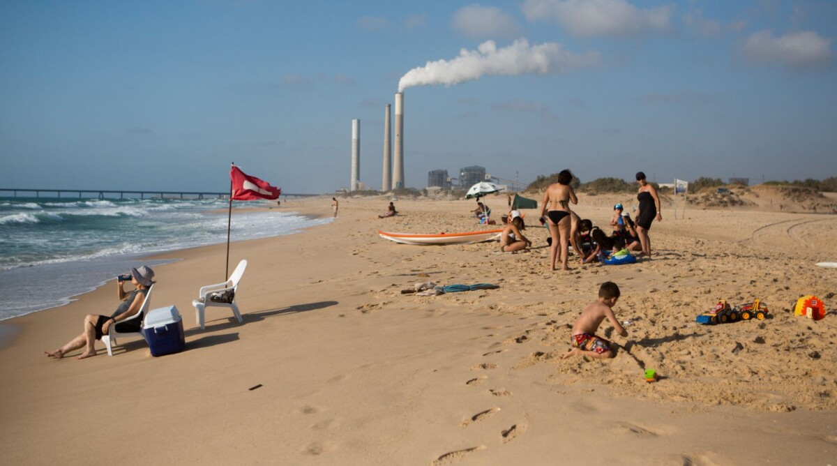 ישראלים נופשים בחוף זיקים, על רקע תחנת הכוח באשקלון, 6.7.15 (צילום: מרים אלסטר)