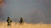 חיילי צה"ל מביטים בשריפה שחוללו טילים שנורו מסוריה ונחתו בגולן, 20.8.15 (צילום: באסל עווידאת)