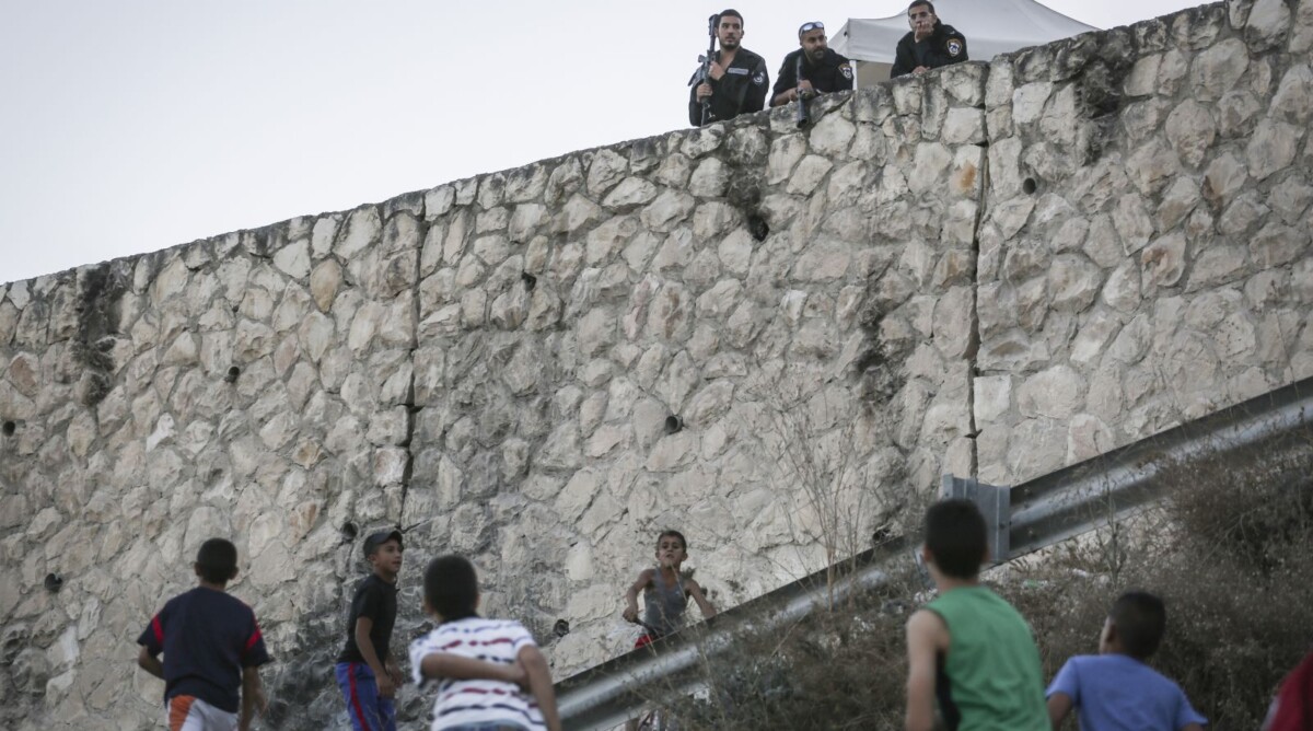שוטרים ישראלים משקיפים על ילדים פלסטינים. הר הזיתים, 21.10.15 (צילום: הדס פרוש)