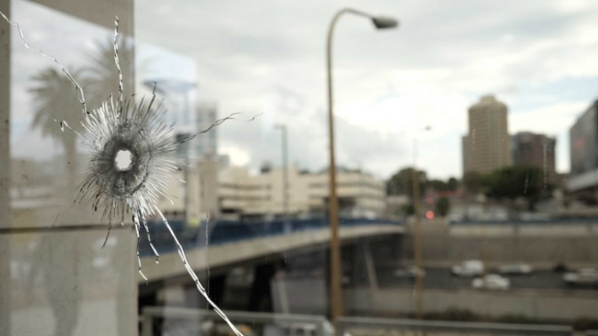 חלון מנוקב מכדור בזירת פיגוע דקירה ליד הקריה בתל-אביב, 8.10.15 (צילום: תומר נויברג)