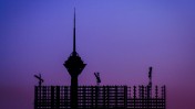מגדל התקשורת מילאד מציץ מעל נוף פיגומים ומנופים בטהראן, איראן (צילום: Mohammadali F, רישיון cc-by-nc-sa)