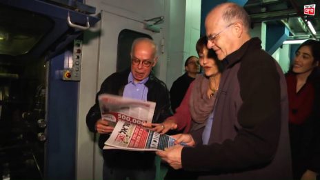 אהרון לפידות, ציפי קורן ועמוס רגב מעיינים בגליונות "ישראל היום" בבית-הדפוס של העיתון, 2014 (צילום מסך מתוך סרטון תדמית)