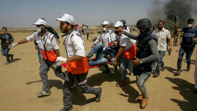 פלסטינים מפנים את צלם העיתונות הפצוע מוחמד אלת'לאת'יני במהלך הפגנות ליד הגבול של רצועת עזה, 11.5.2018 (צילום: עבד רחים ח'טיב)