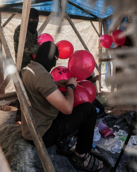 רעולי פנים פלסטינים מכינים בלוני תבערה. רצועת עזה, 25.6.2019 (צילום: חסן ג'די)