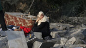 אשה יושבת על שרידי בית שנהרס מפגיעת טיל ישראל, חאן יונס, 13.11.2019 (צילום: פאדי פדח)