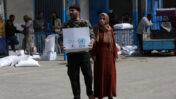 פלסטינים מקבלים חבילות מזון במרכז של אונר"א בחאן יונס, 7.32020 (צילום: פאדי פאהד)