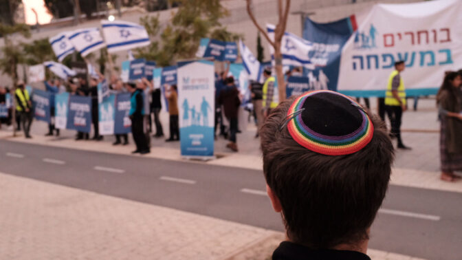 יהודי חובש כיפת גאווה מתבונן על הפגנת פעילים נגד זכויות להט"בים, תל-אביב, 2018 (צילום: תומר נויברג)