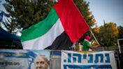 איש נושא את דגל איחוד האמירויות מחוץ למעון ראש הממשלה בירושלים, 19.8.20 (צילום: יונתן זינדל)