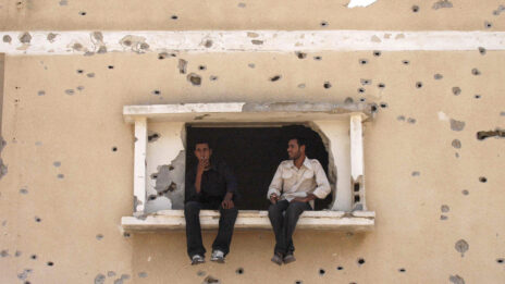 שני פלסטינים מתבוננים לכיוון ציר פילדלפי שהפריד בין עזה למצרים, ספטמבר 2005 (צילום: יוסי זמיר)
