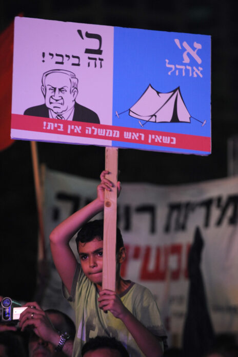 מחאת יוקר המחיה: מפגין צעיר אוחז בשלט בהפגנה בתל-אביב, 30.7.2011 (צילום: גילי יערי)