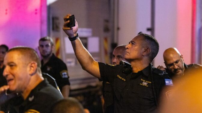 שוטר מצלם מפגינים (צילום: מולי גולדברג)