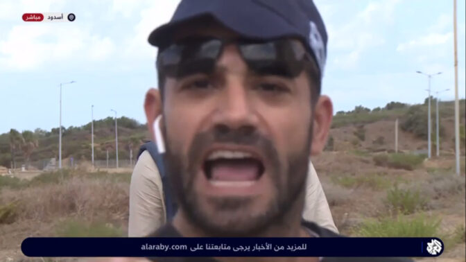 אדם בכובע משטרתי מפריע לשידור אל-ערביה, 15.10.23 (צילום מסך)