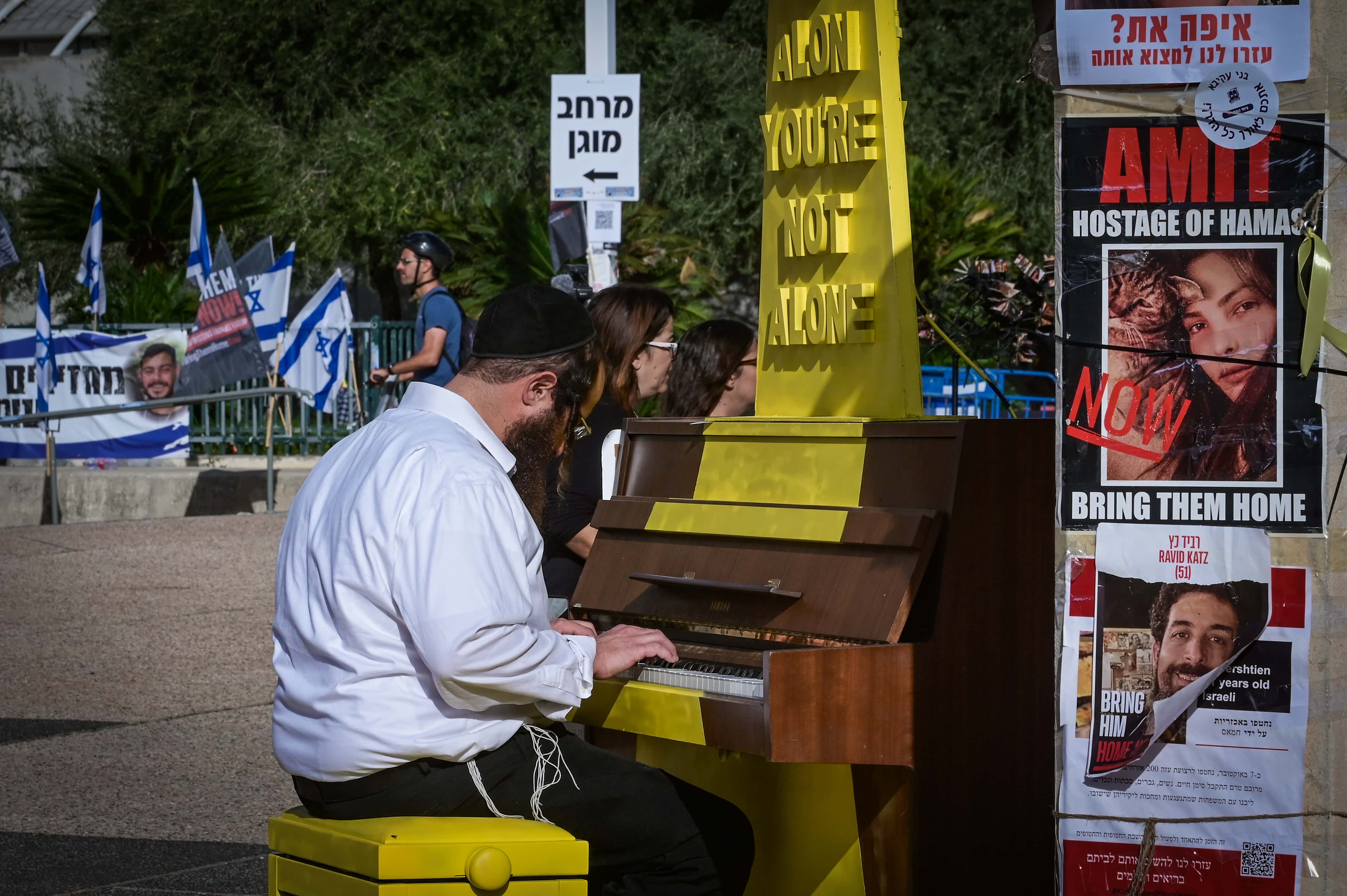 חרדי מנגן על פסנתר שהוצב ב"כיכר החטופים". מוזיאון תל-אביב לאמנות, 23.11.2023 (צילום: אבשלום ששוני)