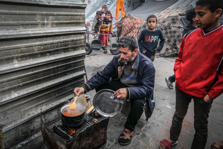 פלסטינים עקורים מכינים ארוחת ערב ברפיח, מרץ 2024 (צילום: עבד רחים ח'טיב)
