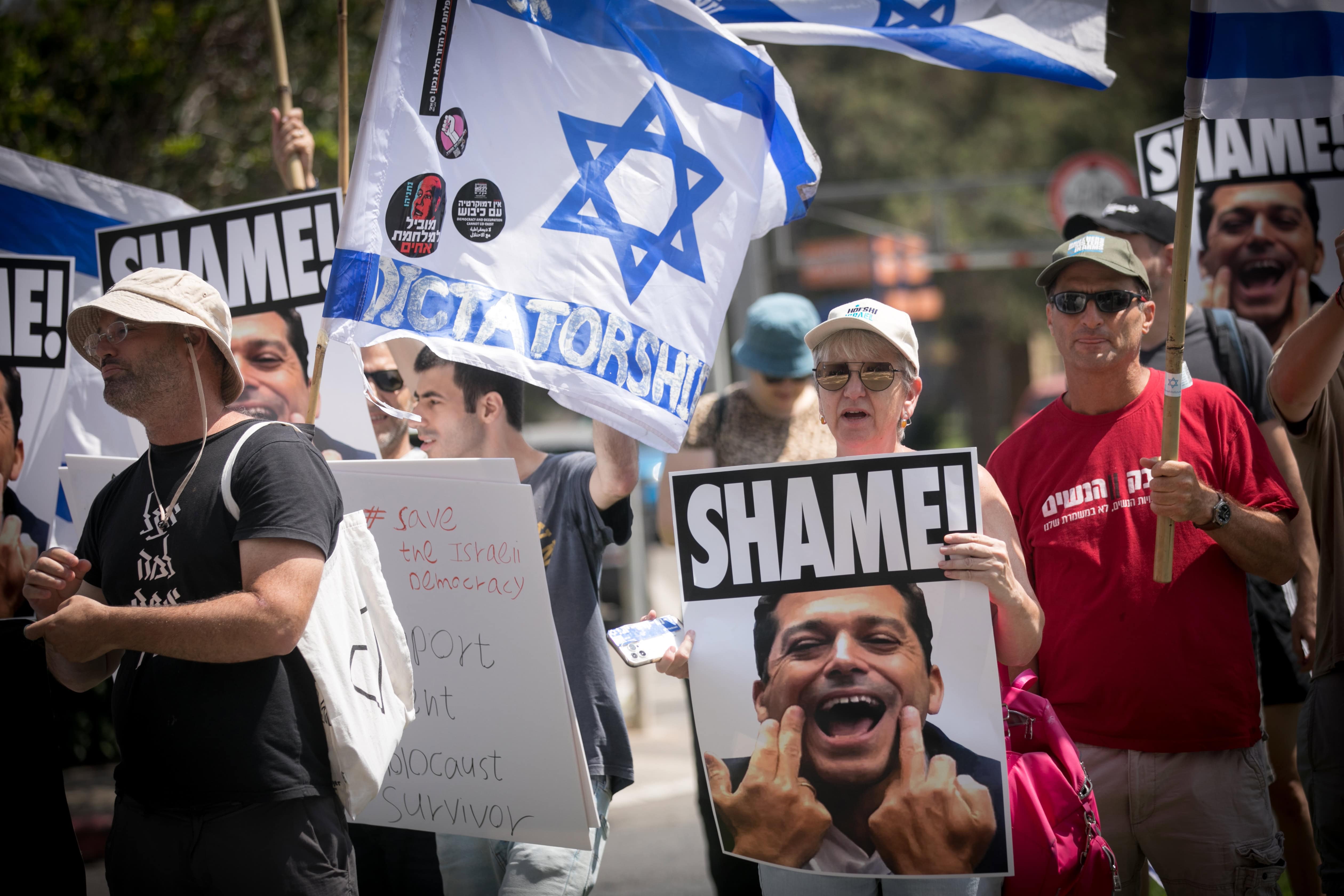 ישראלים נושאים תמונות של השר עמיחי שיקלי מחוץ לאירוע שבו נאם. תל-אביב, 14.6.2023 (צילום: מרים אלסטר)